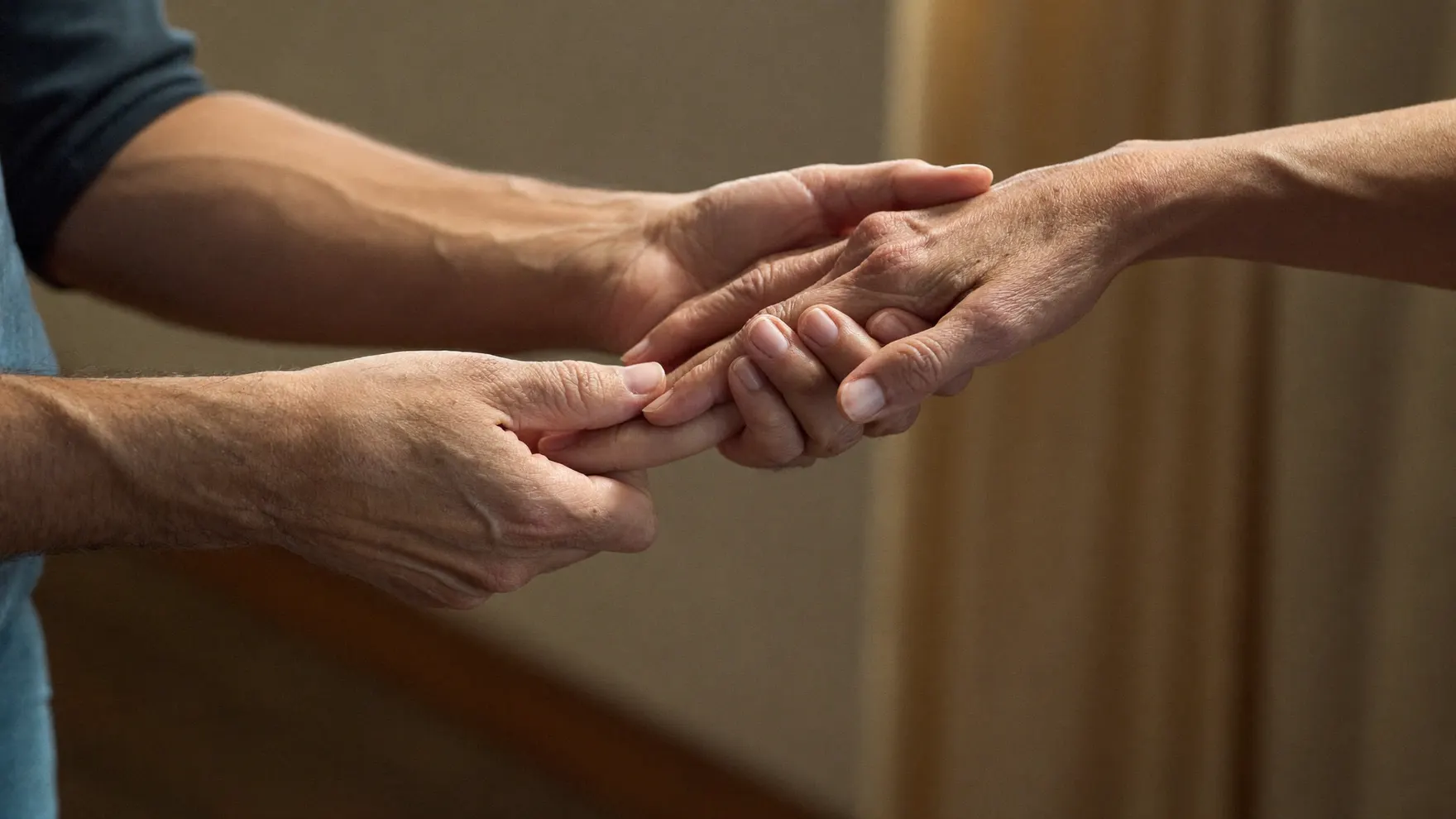 One person gently holding another's hands